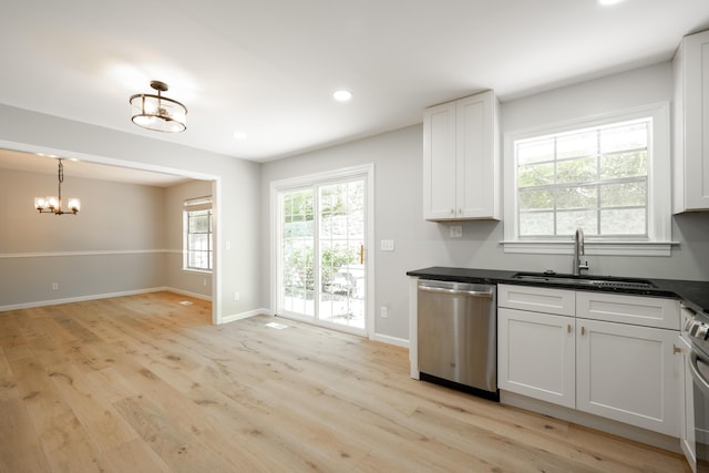 4802 Woodland Cir, Hixson, TN 37343 - kitchen featuring dark countertops, a sink, light wood-style floors, an inviting chandelier, and appliances with stainless steel finishes