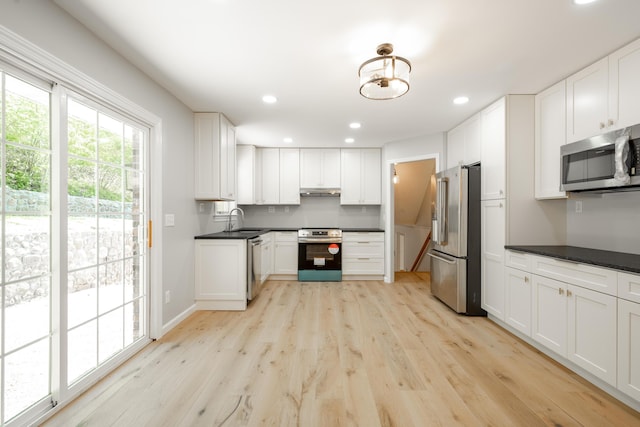 4802 Woodland Cir, Hixson, TN 37343 - kitchen featuring white cabinets, stainless steel appliances, a sink, dark countertops, and light wood-style floors