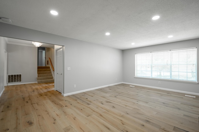 4802 Woodland Cir, Hixson, TN 37343 - empty room with recessed lighting, stairway, visible vents, light wood-style floors, and a textured ceiling