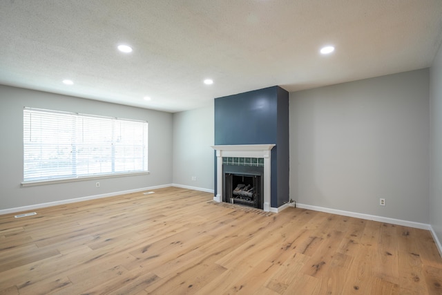 4802 Woodland Cir, Hixson, TN 37343 - unfurnished living room featuring light wood-style flooring, visible vents, recessed lighting, and a fireplace