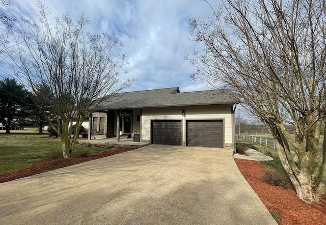 ranch-style home with driveway, roof with shingles, and an attached garage