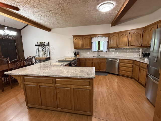 kitchen with stainless steel appliances, light wood-type flooring, a peninsula, and a sink