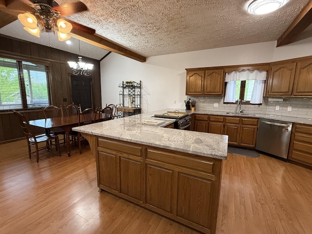 kitchen featuring a sink, stainless steel appliances, backsplash, light wood-style flooring, and ceiling fan with notable chandelier