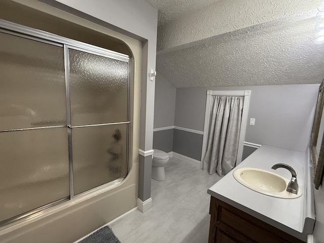 bathroom featuring lofted ceiling, a textured ceiling, combined bath / shower with glass door, toilet, and vanity