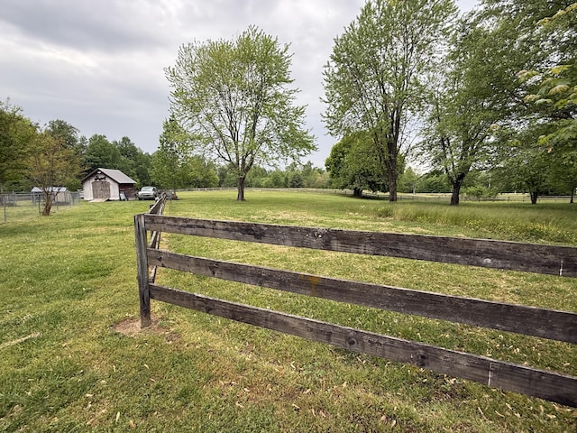 view of gate featuring fence, a rural view, and a yard