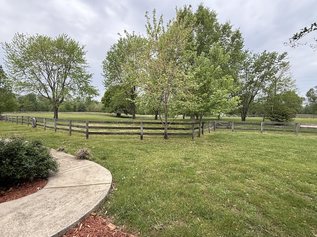 view of yard with fence and a rural view