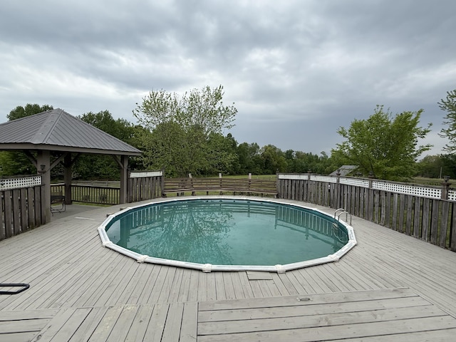 view of pool with a fenced in pool, a deck, a gazebo, and fence
