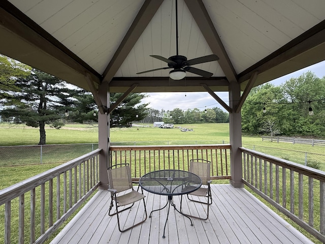 wooden terrace featuring a yard, fence, a gazebo, ceiling fan, and outdoor dining area