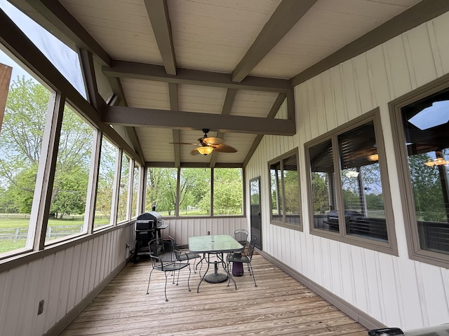 sunroom / solarium with outdoor dining space, a ceiling fan, and beamed ceiling