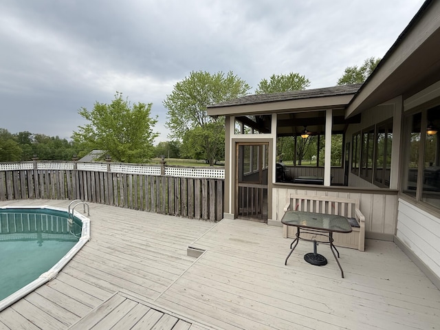 wooden terrace with a sunroom, a fenced in pool, and fence