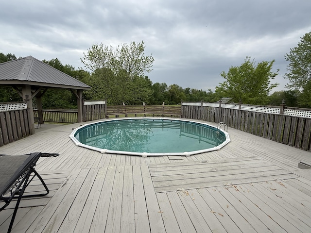 view of swimming pool with a fenced in pool, a deck, a gazebo, and fence