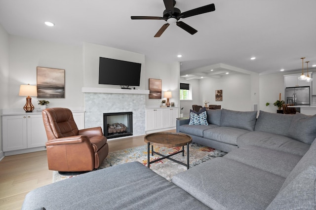 living room with recessed lighting, light wood finished floors, ceiling fan, and a fireplace