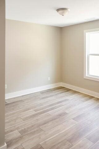 spare room with light wood finished floors and baseboards