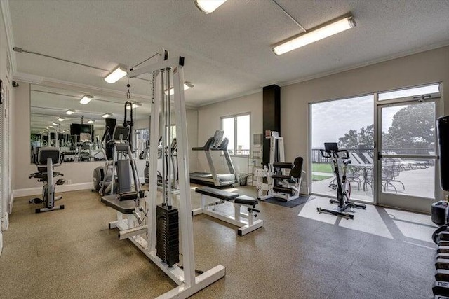 workout area featuring a textured ceiling, baseboards, and ornamental molding
