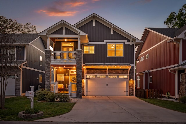 craftsman-style house with stone siding, concrete driveway, an attached garage, a balcony, and a front yard