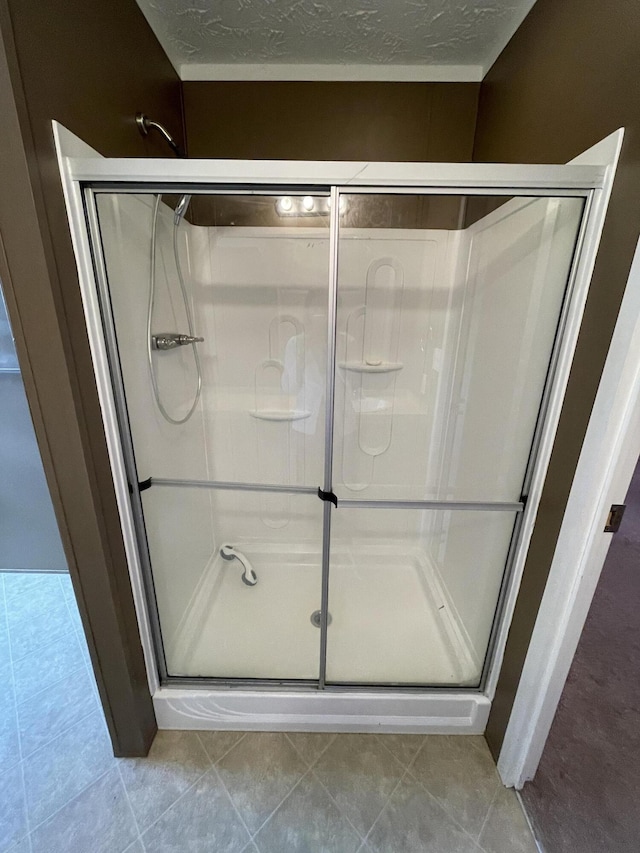 417 Chester St, Athens, TN 37303 - bathroom featuring tile patterned floors, a textured ceiling, and a shower stall