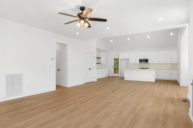 unfurnished living room featuring recessed lighting, vaulted ceiling, visible vents, and a ceiling fan