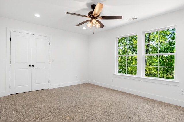carpeted empty room with recessed lighting, visible vents, a ceiling fan, and baseboards