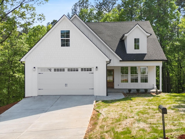 modern inspired farmhouse with board and batten siding, a shingled roof, driveway, and a front yard
