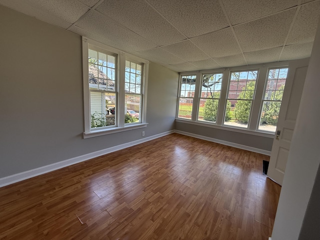 110 7th St, South Pittsburg, TN 37380 - spare room with a drop ceiling, baseboards, wood finished floors, and healthy amount of natural light