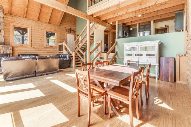 159 Eagle Creek Trl, Rising Fawn, GA 30738 - dining room with rustic walls, wood finished floors, stairs, beam ceiling, and high vaulted ceiling
