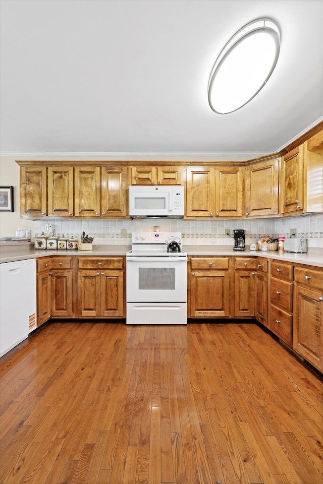 kitchen featuring brown cabinetry, decorative backsplash, white appliances, light countertops, and dark wood finished floors