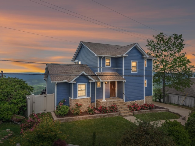 view of front of house featuring fence, a gate, and stone siding