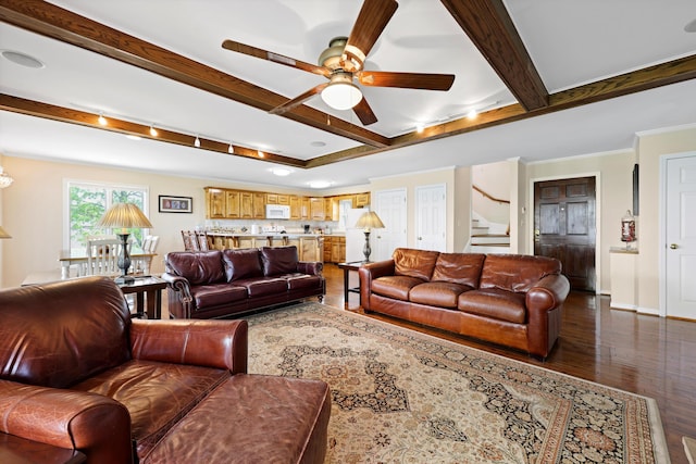 living area with dark wood finished floors, baseboards, beamed ceiling, a ceiling fan, and stairs