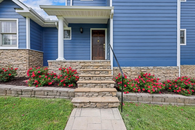 property entrance with stone siding and covered porch