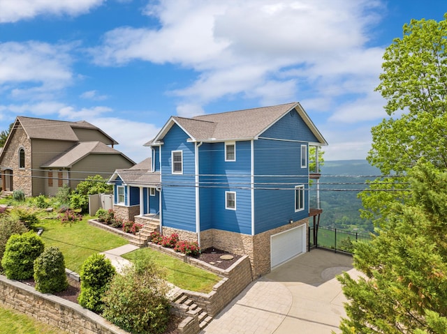 view of front of house featuring a front lawn, driveway, stone siding, fence, and a garage