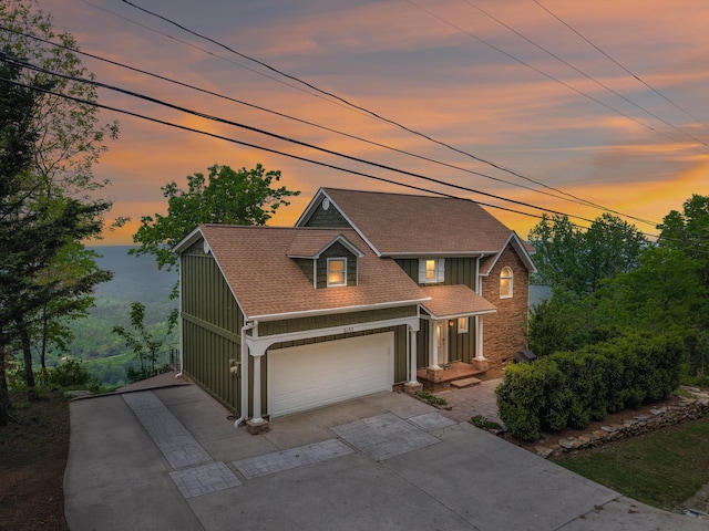 traditional-style house with driveway, board and batten siding, a shingled roof, and a garage