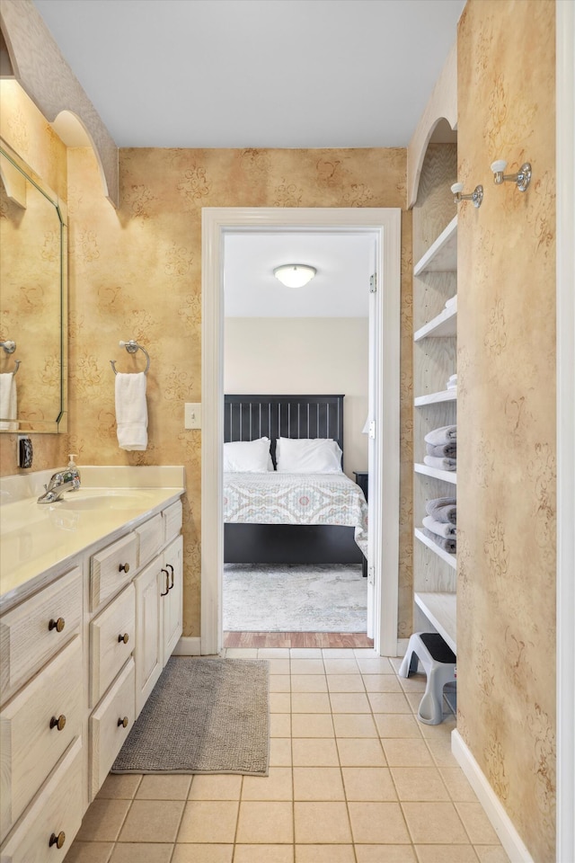 bathroom with tile patterned floors, baseboards, vanity, and connected bathroom