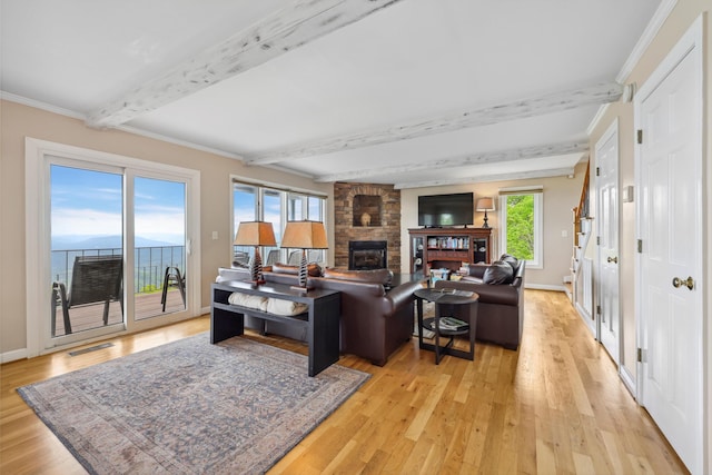 living room with beamed ceiling, visible vents, a fireplace, and light wood-type flooring
