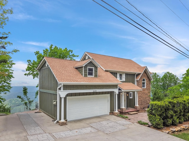 traditional-style home featuring fence, driveway, a shingled roof, and board and batten siding