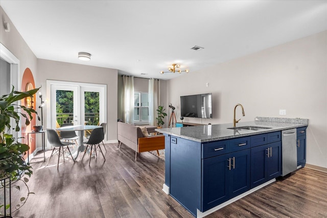 kitchen with visible vents, blue cabinets, a sink, a peninsula, and dark wood-style flooring