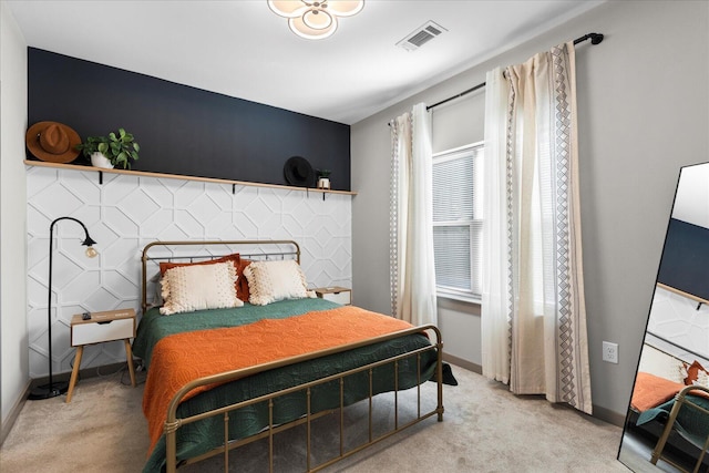 bedroom featuring baseboards, visible vents, and light colored carpet