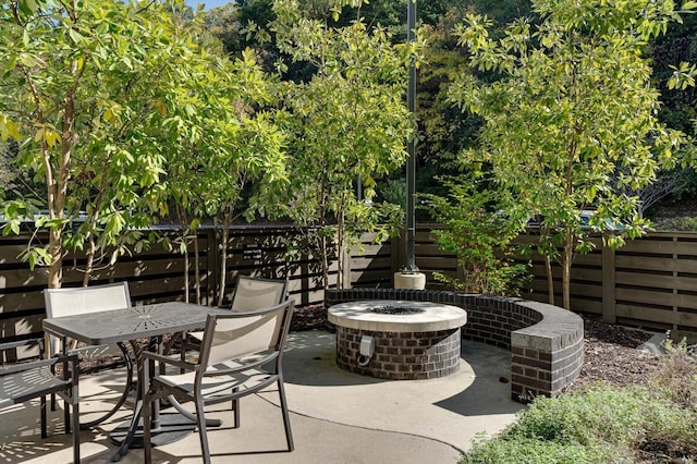 view of patio / terrace with outdoor dining space, an outdoor fire pit, and fence
