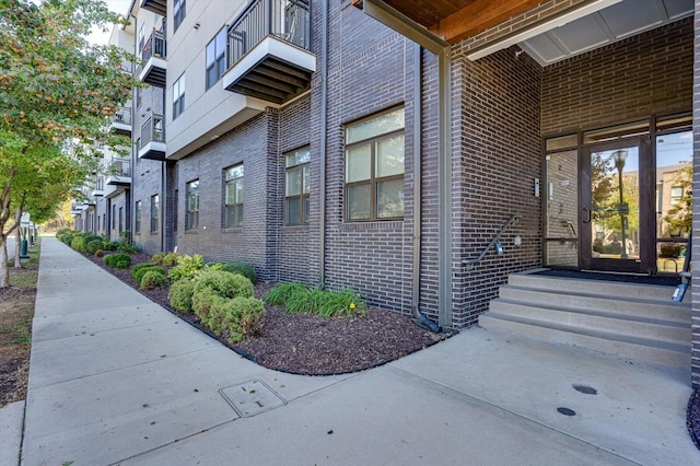 entrance to property featuring brick siding