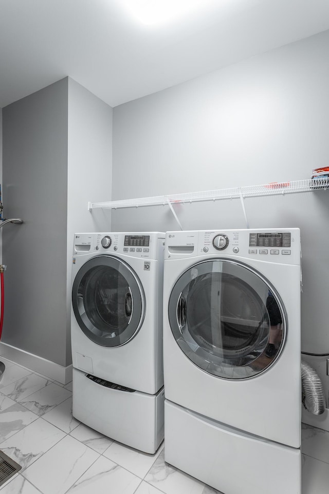 229 Courtland Crest Dr SW, Cleveland, TN 37311 - laundry room featuring light marble finish flooring, washer and clothes dryer, and baseboards