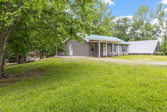 ranch-style home featuring a front lawn and metal roof