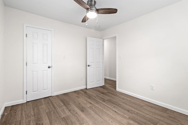 unfurnished bedroom with baseboards, a ceiling fan, and wood finished floors