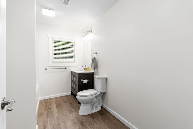 full bathroom featuring toilet, baseboards, wood finished floors, and vanity