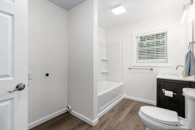 bathroom featuring vanity, toilet, baseboards, and wood finished floors