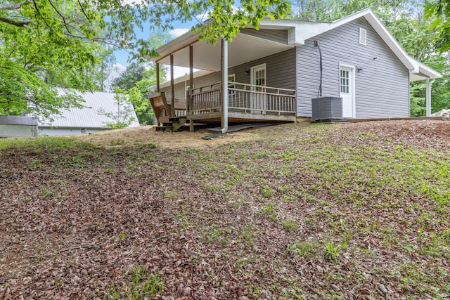 rear view of property with cooling unit and a wooden deck