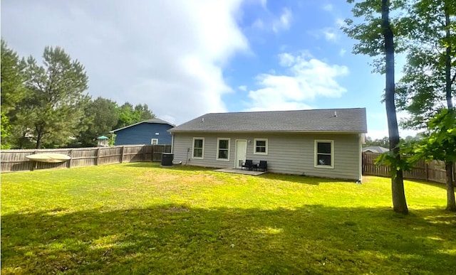 back of property with a lawn and a fenced backyard