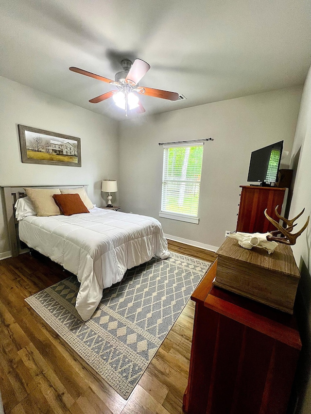 bedroom featuring baseboards, ceiling fan, and wood finished floors