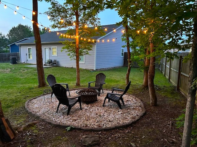 view of yard with a fenced backyard, an outdoor fire pit, and central air condition unit