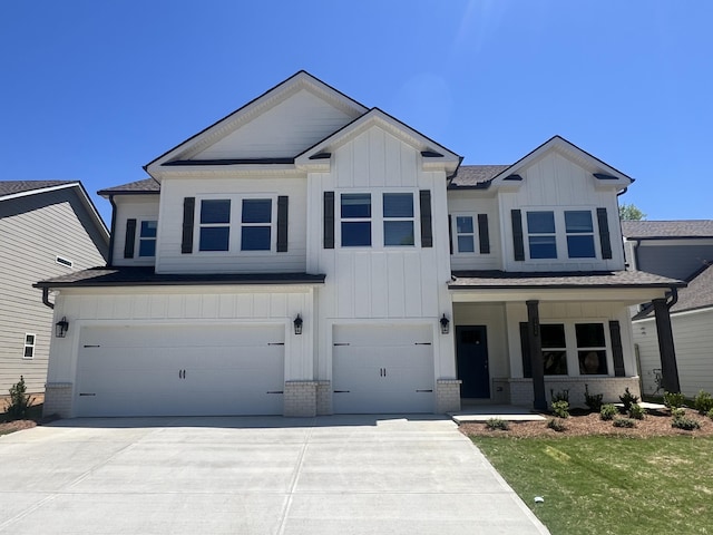 view of front facade featuring board and batten siding, driveway, brick siding, and a garage