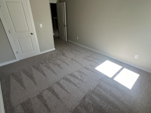 unfurnished bedroom featuring baseboards and carpet