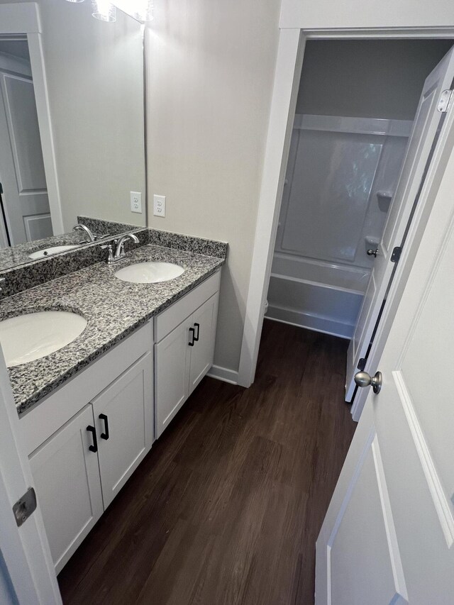 bathroom with double vanity, wood finished floors, and a sink